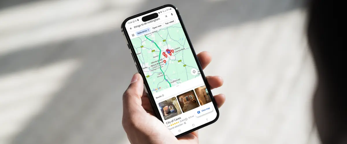 Someone holding a mobile phone up showing google maps results for things to do in Nottingham